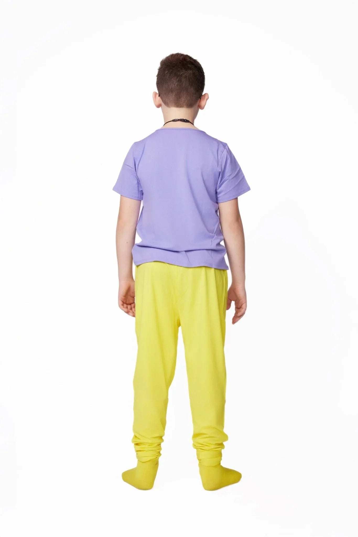 Child wearing sensory-friendly purple shirt and yellow pants, shown from the back