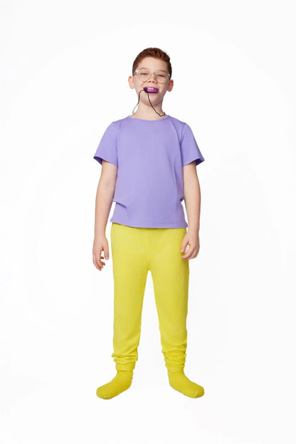Child in sensory-friendly purple shirt and yellow pants with chewable necklace