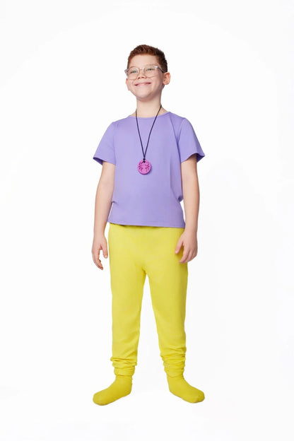 Child wearing sensory-friendly purple shirt, yellow pants, and pink chewable necklace