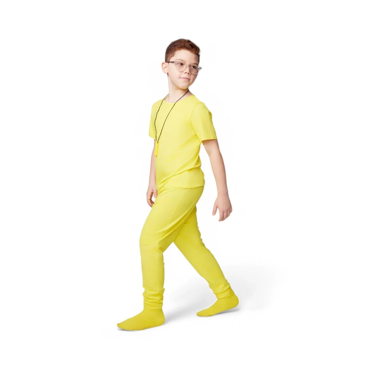 Child in yellow sensory-friendly pajamas and necklace on white background