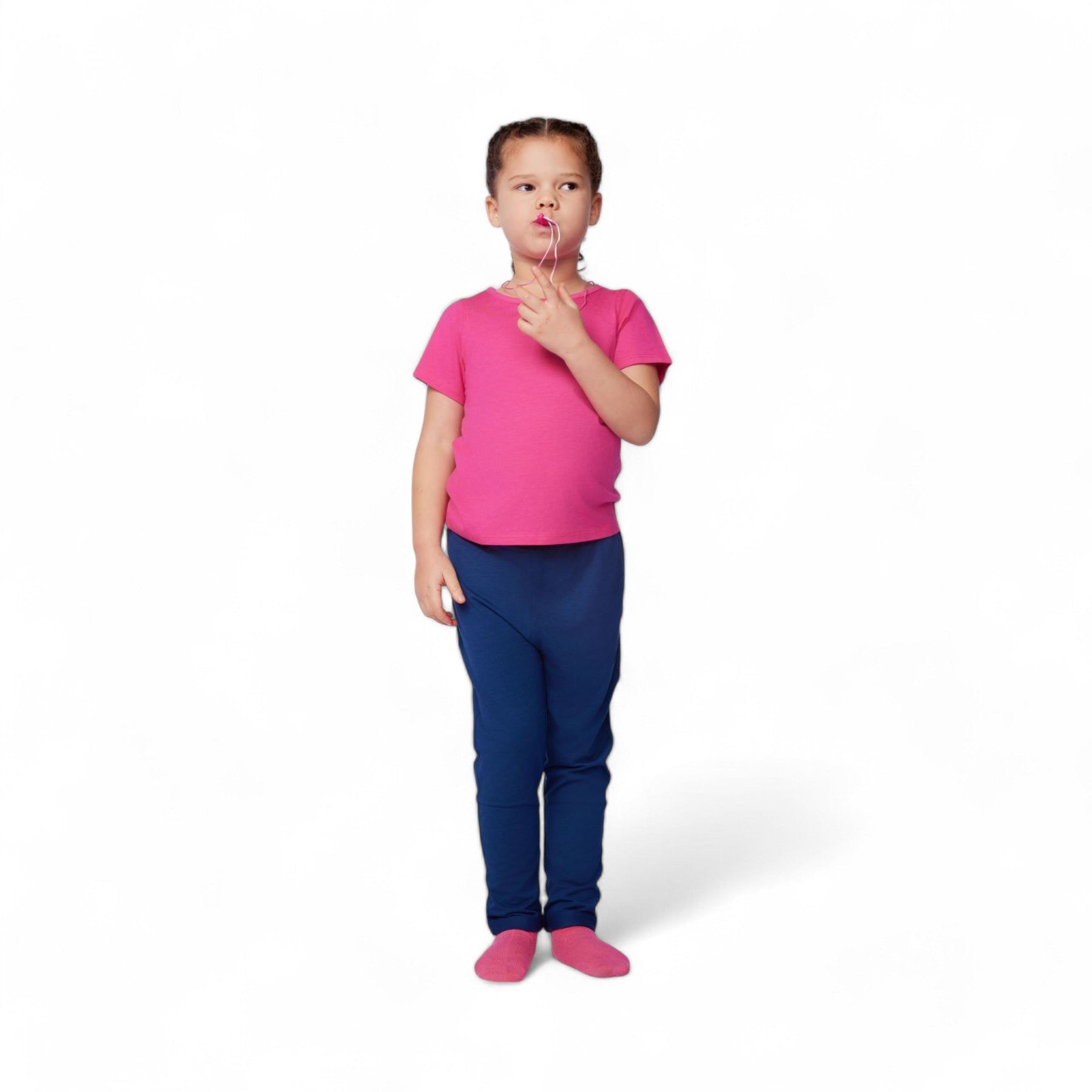 Child wearing a pink shirt and blue pants on a white background