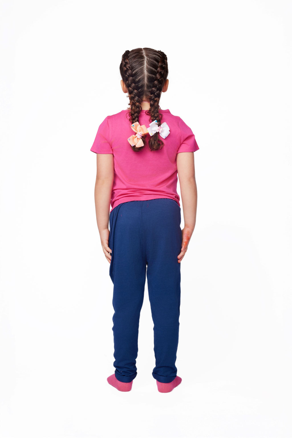 Girl wearing a pink shirt and blue pants on a white background