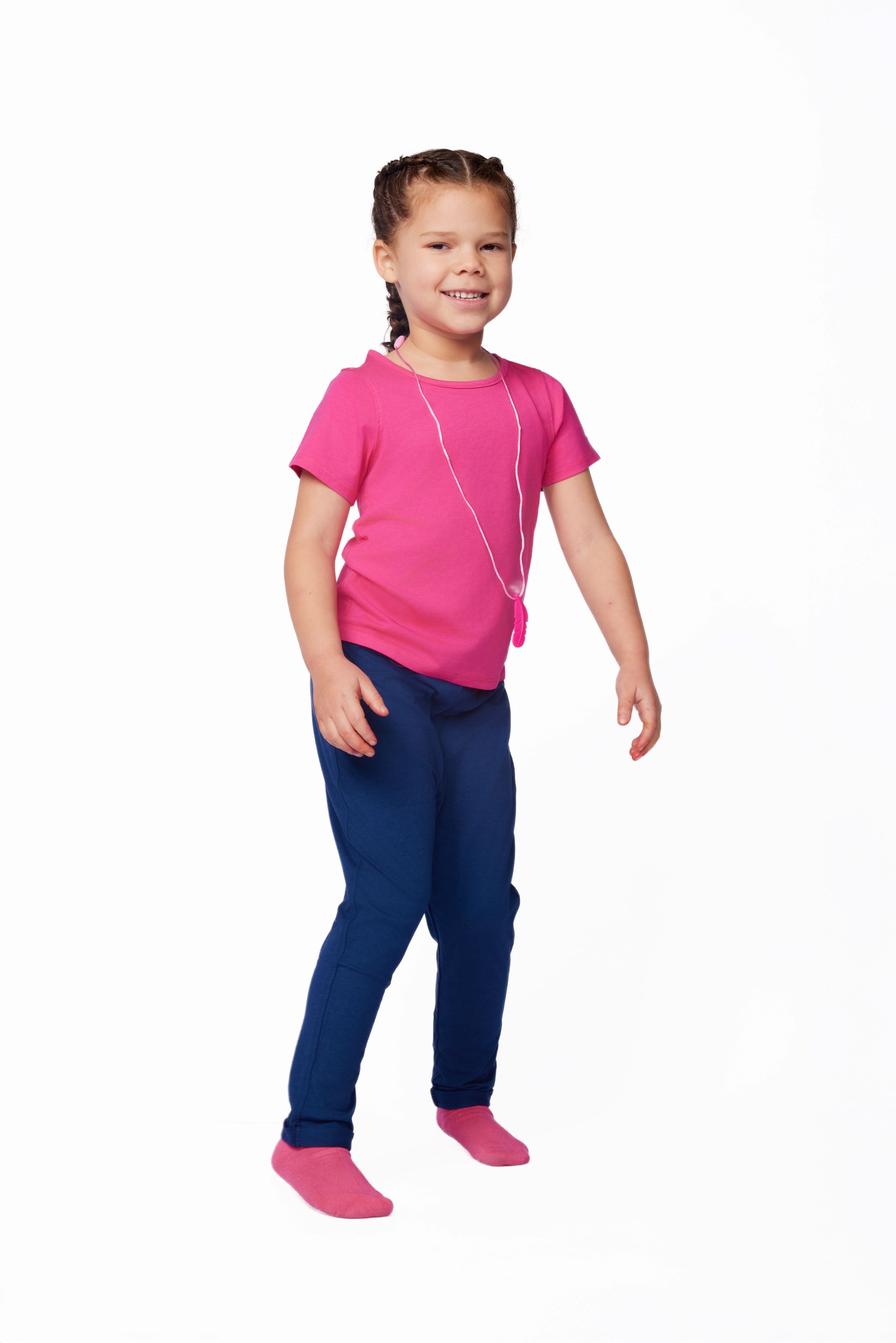 Young girl wearing a pink shirt and blue pants on a white background