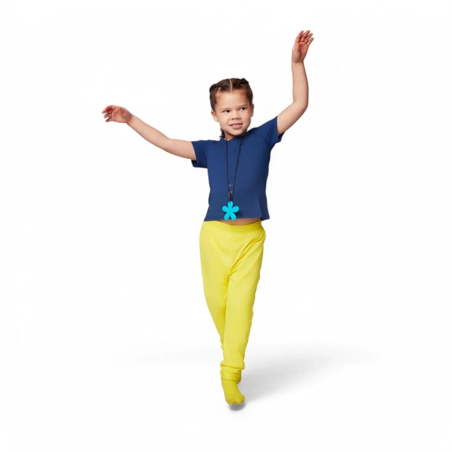 Child in sensory-friendly clothing, blue top, yellow pants, and blue chewable necklace