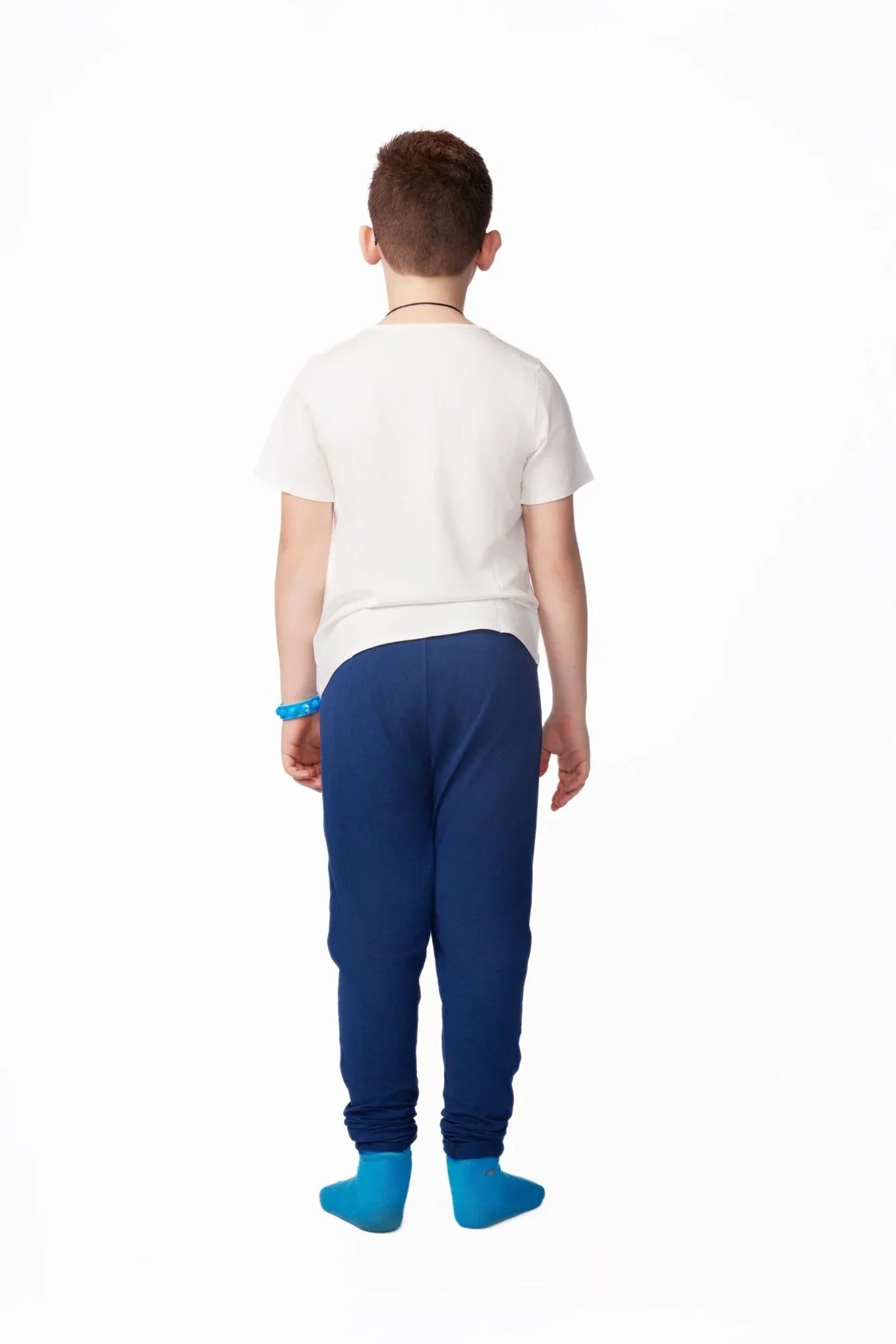 Child wearing sensory-friendly white t-shirt and blue pants, back view on white background