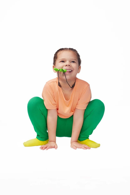 Child wearing sensory-friendly clothes chewing on green oral sensory chew necklace