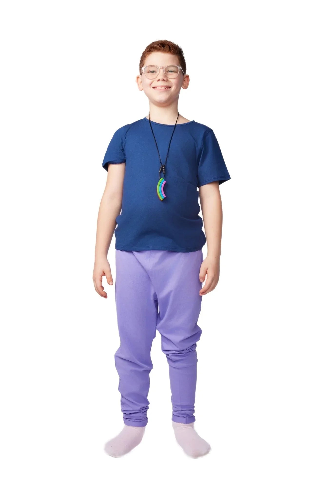 Child in sensory-friendly blue shirt and purple pants with rainbow chew necklace