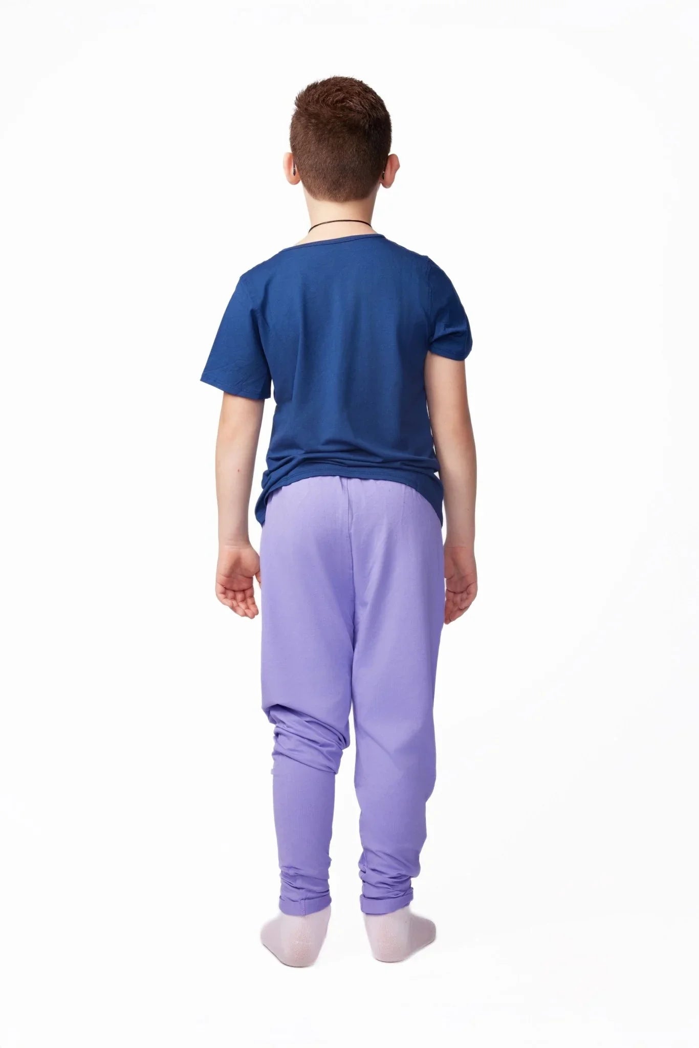 Child wearing sensory-friendly blue shirt and purple pants, back view