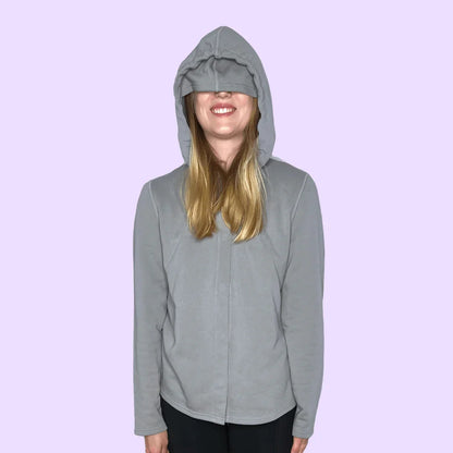 Adult wearing sensory-friendly grey hoodie with oversized hood, lavender background