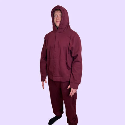 Man wearing maroon sensory-friendly hoodie and pants set, purple background
