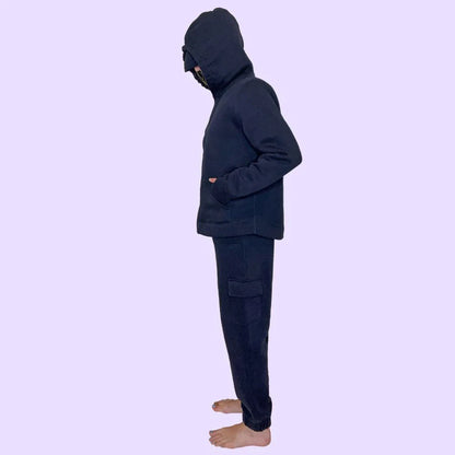 Person wearing a dark sensory-friendly hoodie and joggers set, side view, barefoot