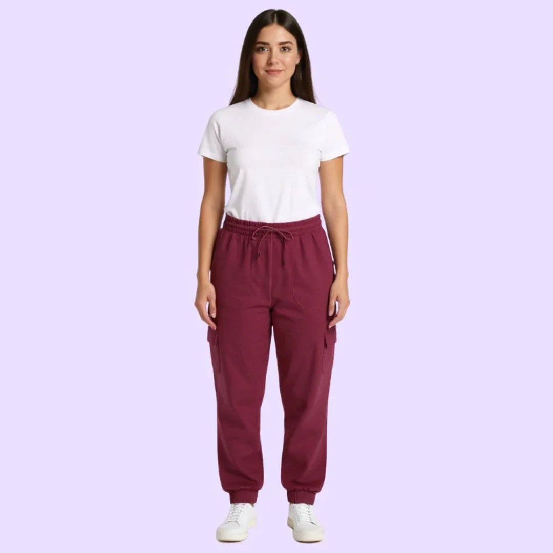 Woman wearing sensory-friendly maroon jogger pants and a white t-shirt on light purple background