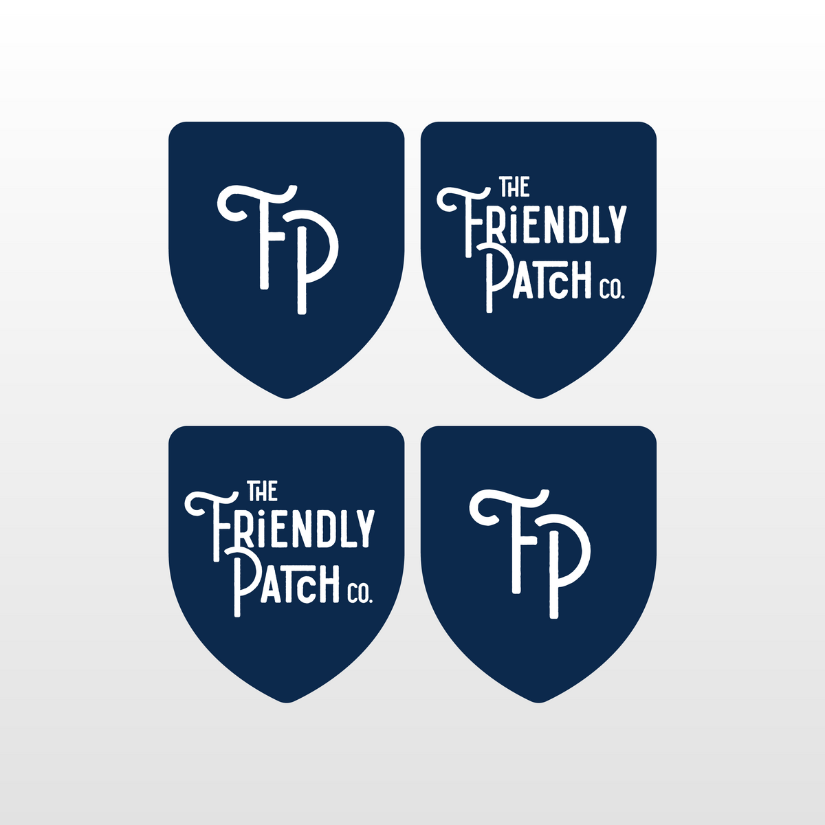 Four blue shield-shaped patches with 'The Friendly Patch co.' text on a light gray background