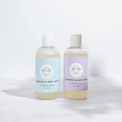 Two bottles of 8 Sheep Organics shampoo and body wash with pastel blue and purple labels.