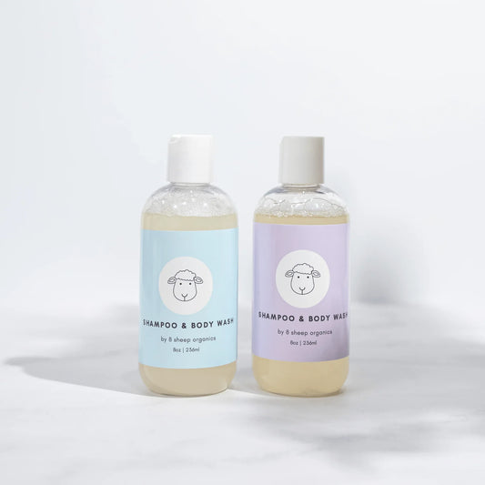 Two bottles of 8 Sheep Organics shampoo and body wash with pastel blue and purple labels.