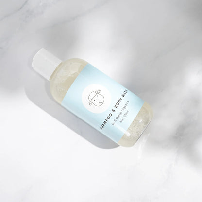Gentle organic shampoo and body wash bottle with sheep logo on light blue label, marble background