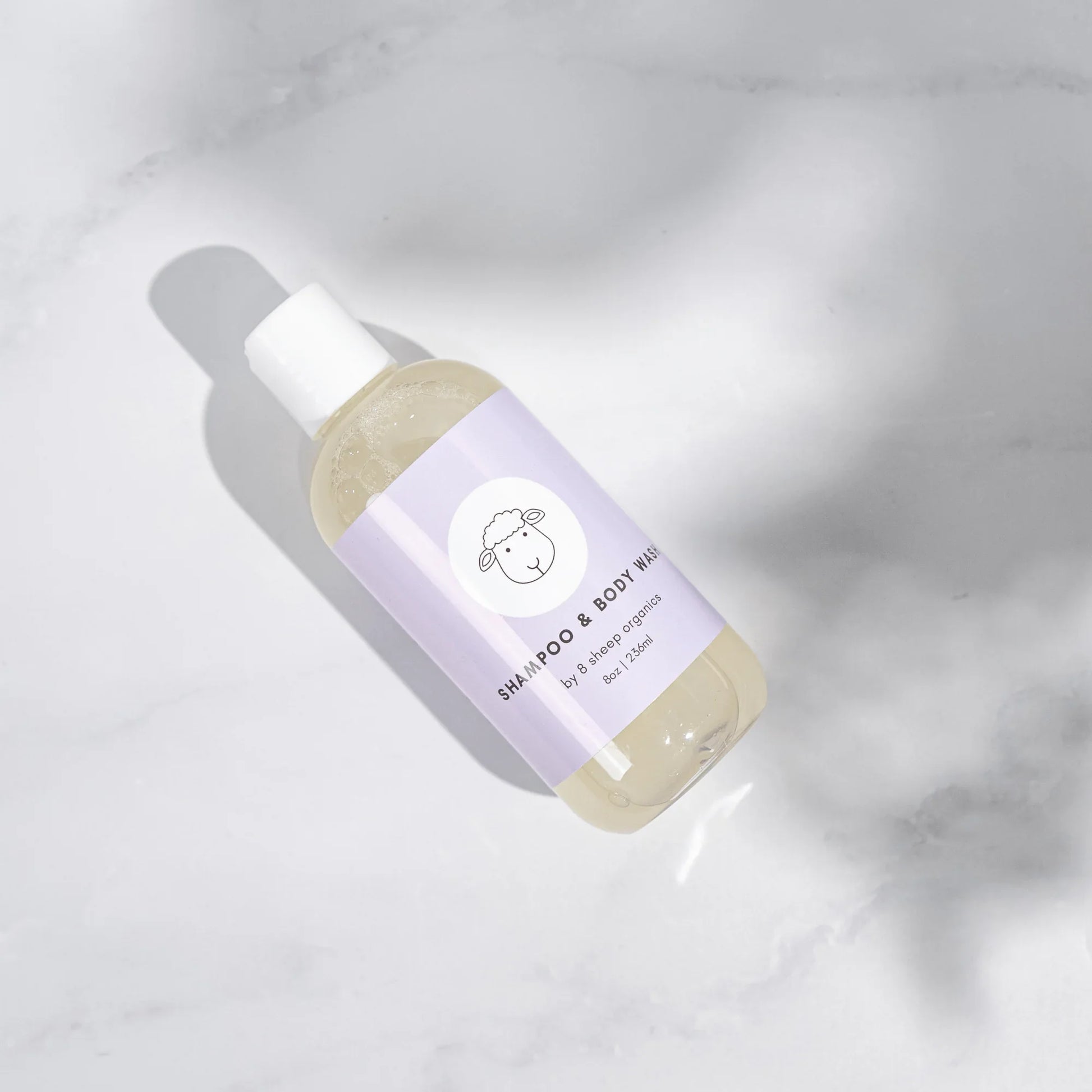 9 Sheep Organics shampoo and body wash bottle with light purple label on white marble surface