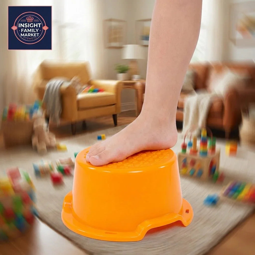 Child's bare foot standing on orange sensory balance stool in a playroom with scattered toys