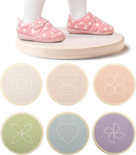 Child in pink polka dot slippers standing on wooden sensory balance board with geometric pattern disks