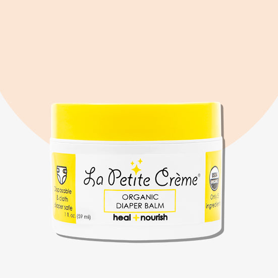 Jar of La Petite Crème organic diaper balm on a beige background