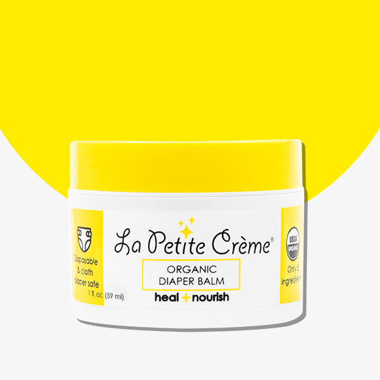 Jar of La Petite Crème organic diaper balm with a yellow lid on a white background