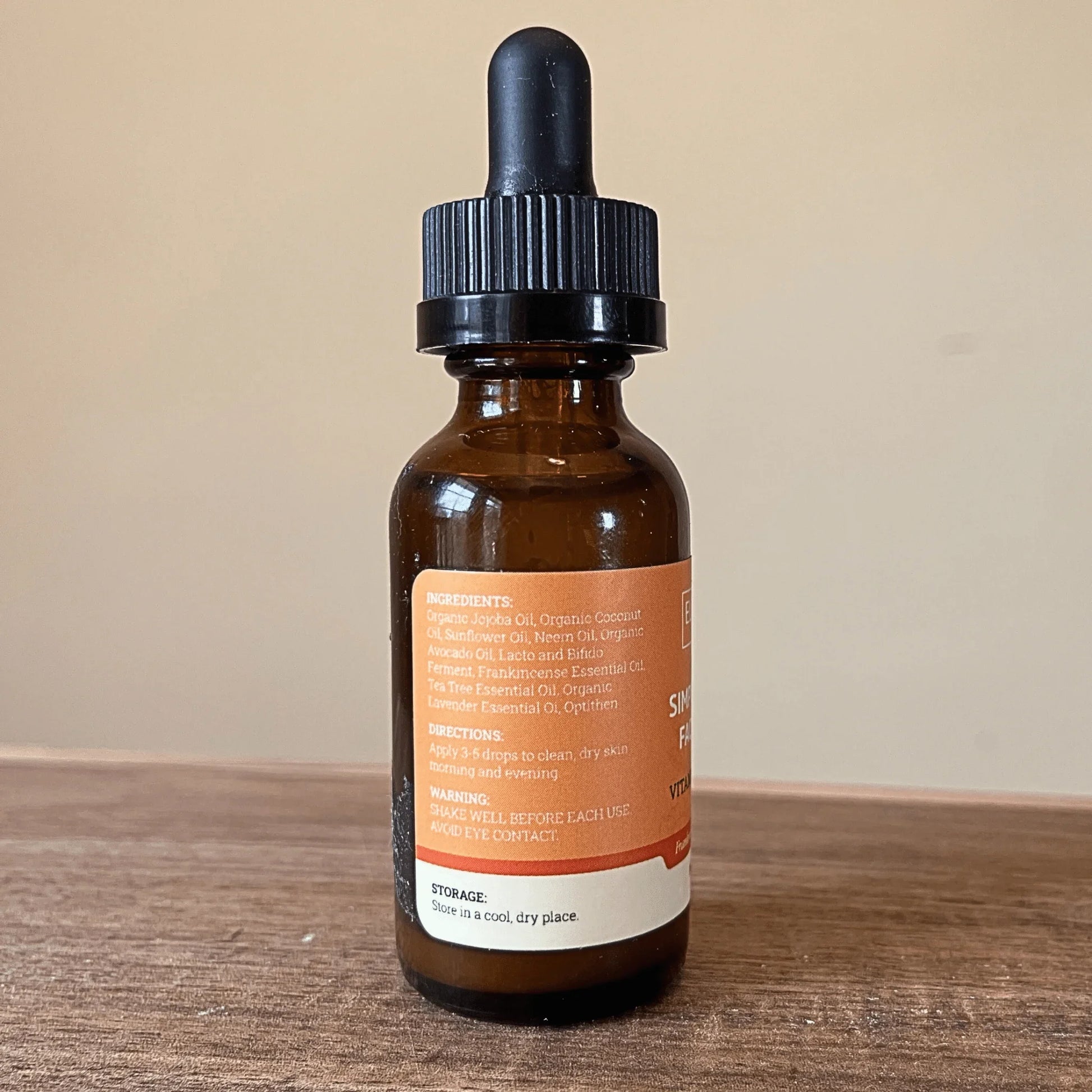 Brown glass dropper bottle of probiotic facial serum with vitamin C, label listing natural ingredients
