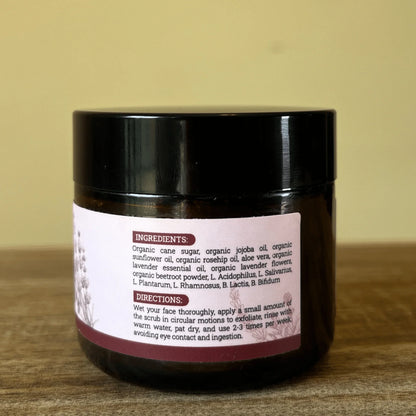 Probiotic face scrub in a dark jar with ingredients and directions label on wooden surface.