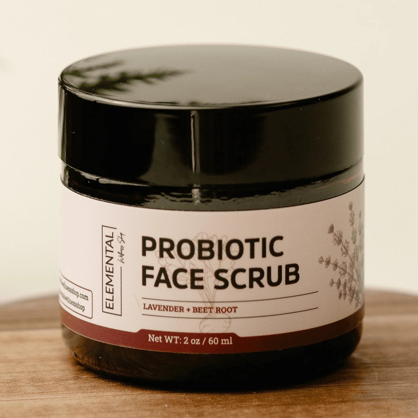 Probiotic face scrub jar with lavender and beet root on wooden surface, natural skincare product