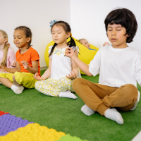 Children sitting on a colorful mat in a classroom setting