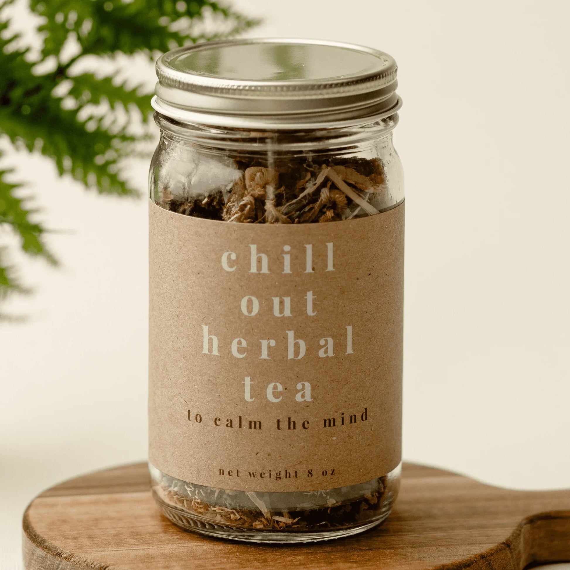 Glass jar of loose leaf chill out herbal tea for relaxation on wooden board