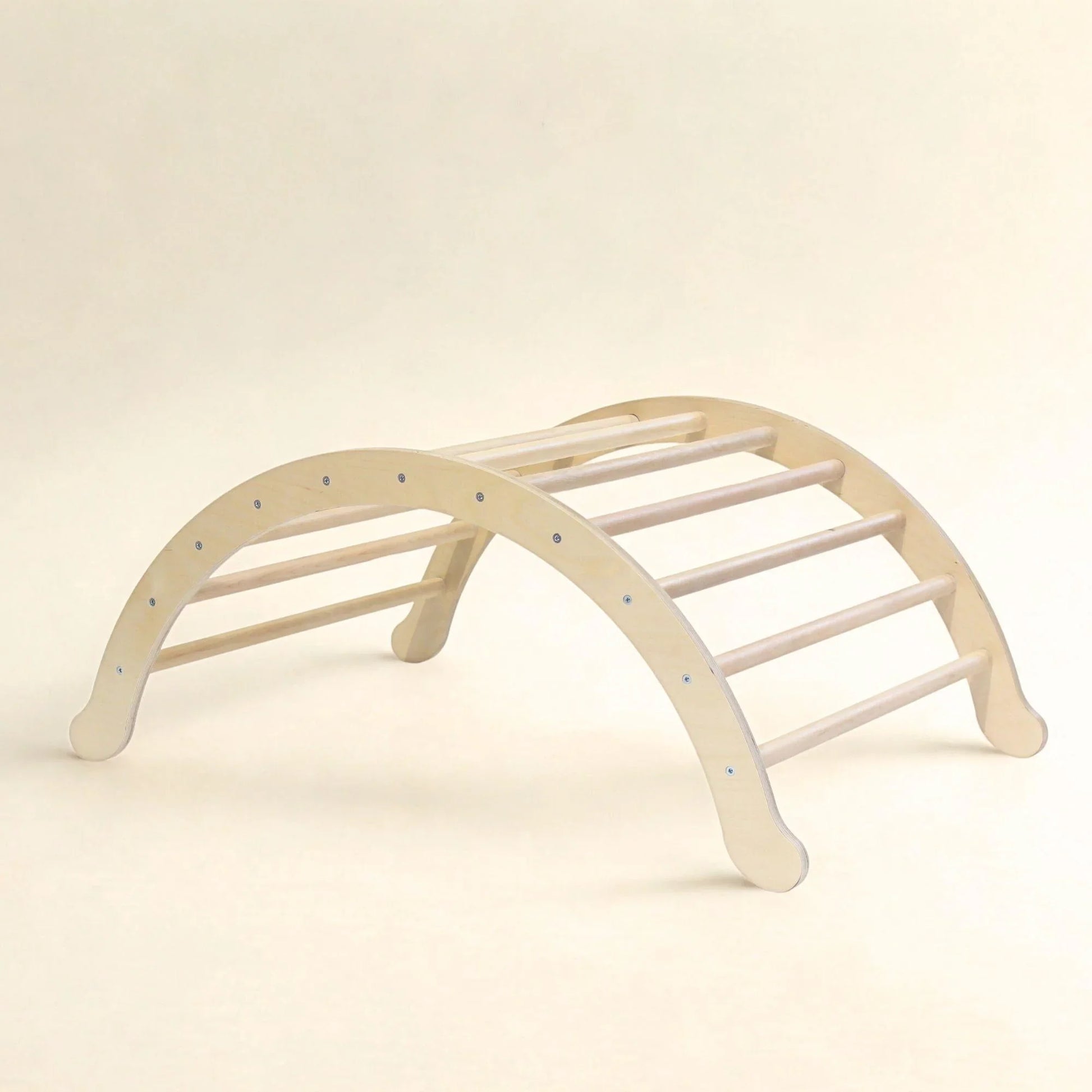 Wooden Pikler climbing arch for sensory play and motor skill development on neutral background