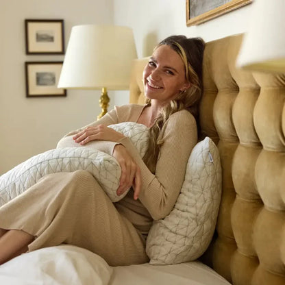 Woman relaxing on bed with a quilted ergonomic pillow in cozy bedroom setting