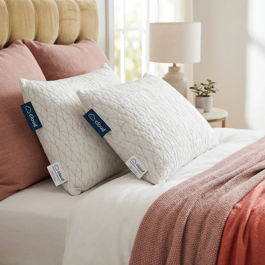 Two quilted memory foam pillows on a neatly made bed with pink accents