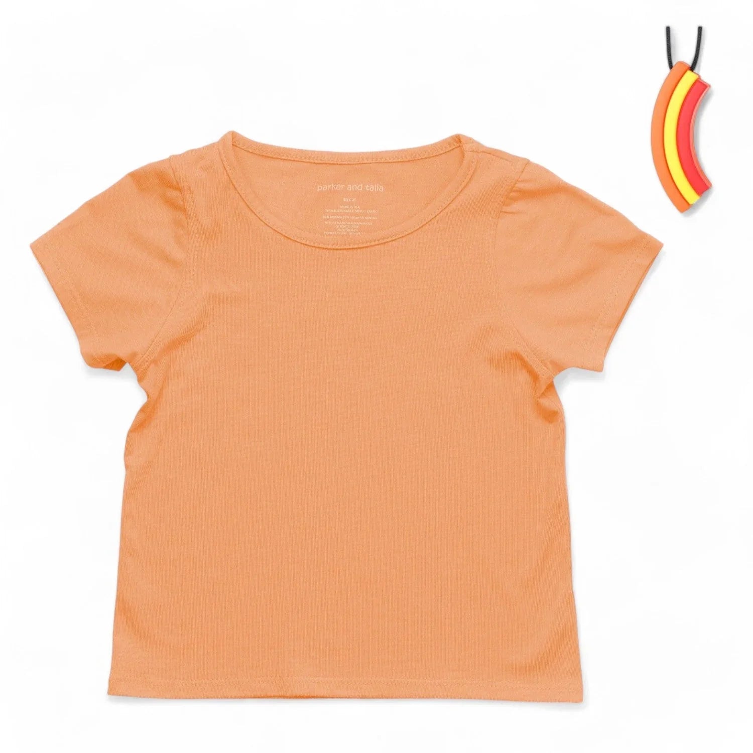 Coral short sleeve sensory-friendly kids' shirt with banana chewable necklace on white background