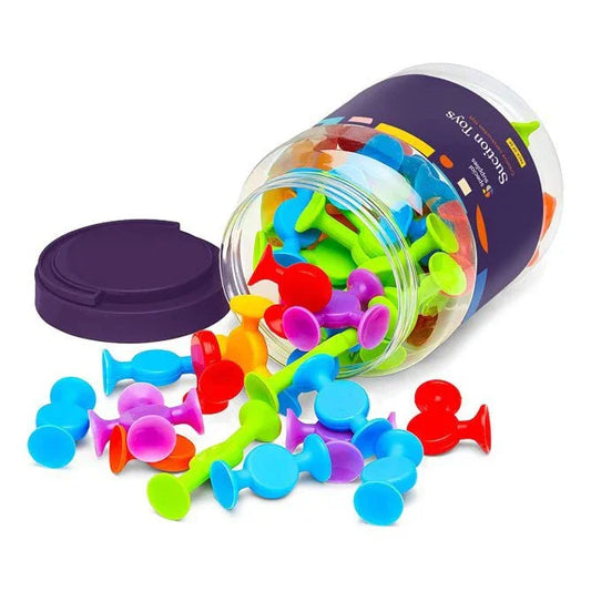 Jar of colorful silicone suction sensory toys for kids, spilled on a white surface
