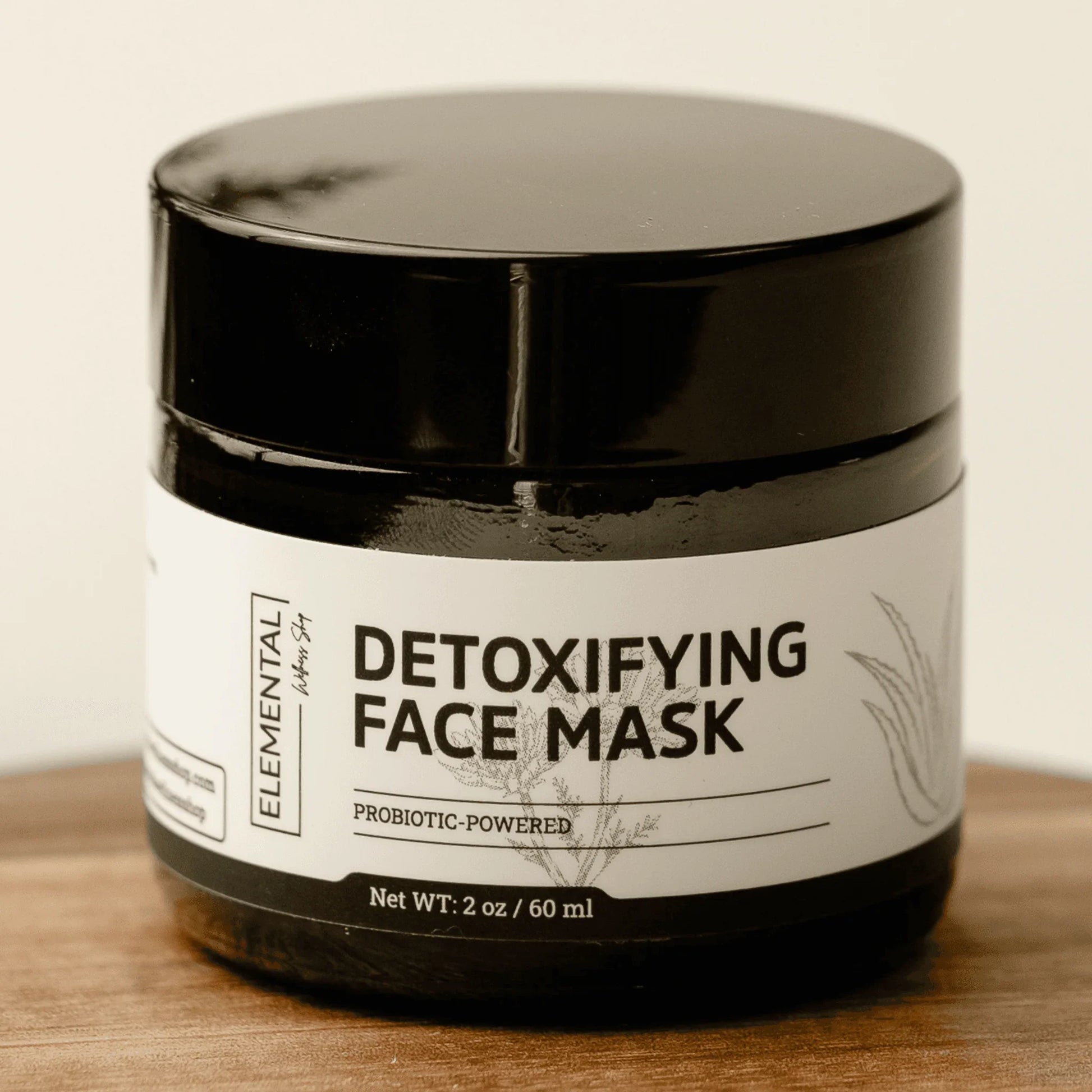Detoxifying face mask jar with probiotic-powered formula on wooden surface