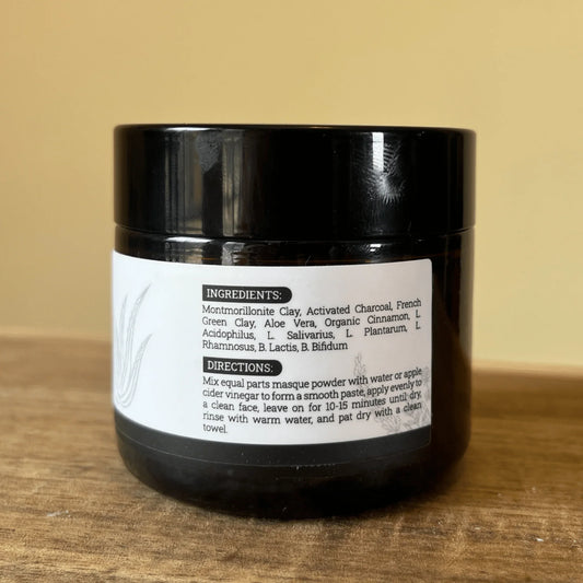 Detoxifying face mask jar with ingredient and direction label on wooden surface