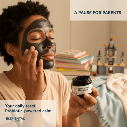 Parent applying detoxifying face mask, relaxing in cozy home setting with books and toys.