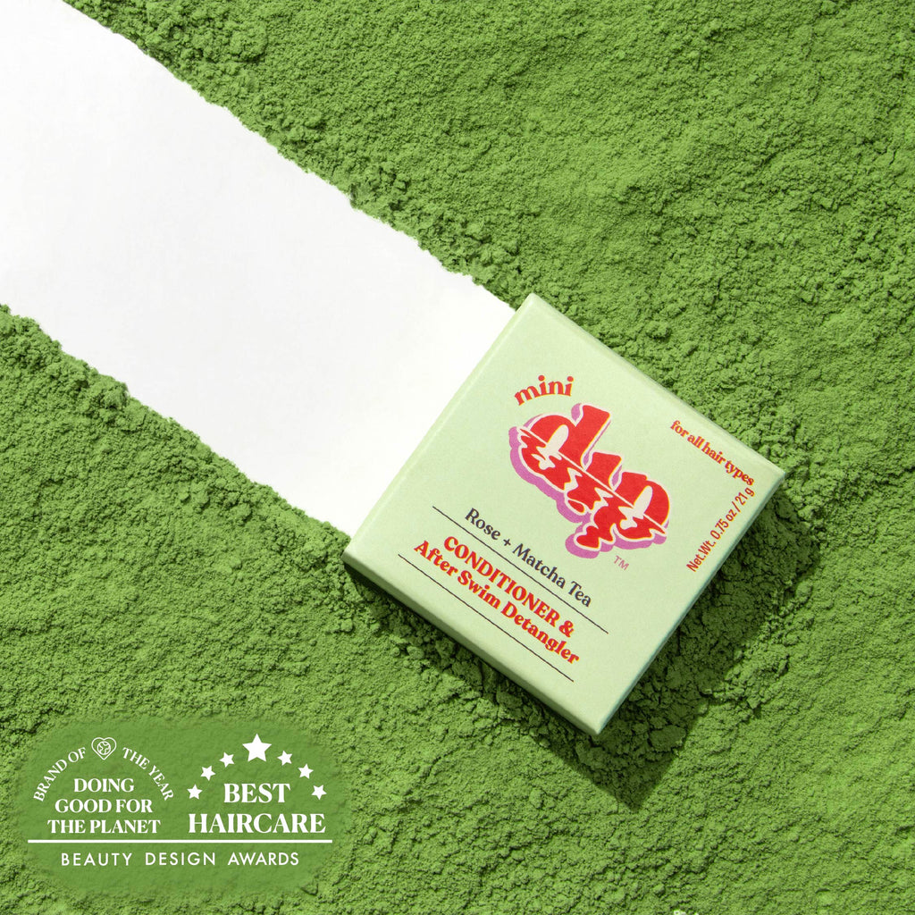 Green box of a hair care product on a green textured background with awards text.