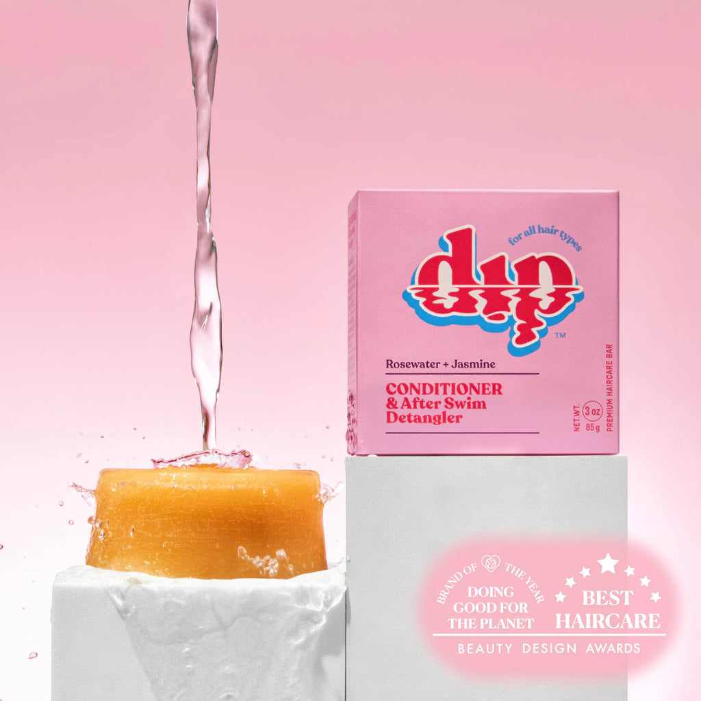Dip soap with water being poured over it, next to its packaging on a pink background.