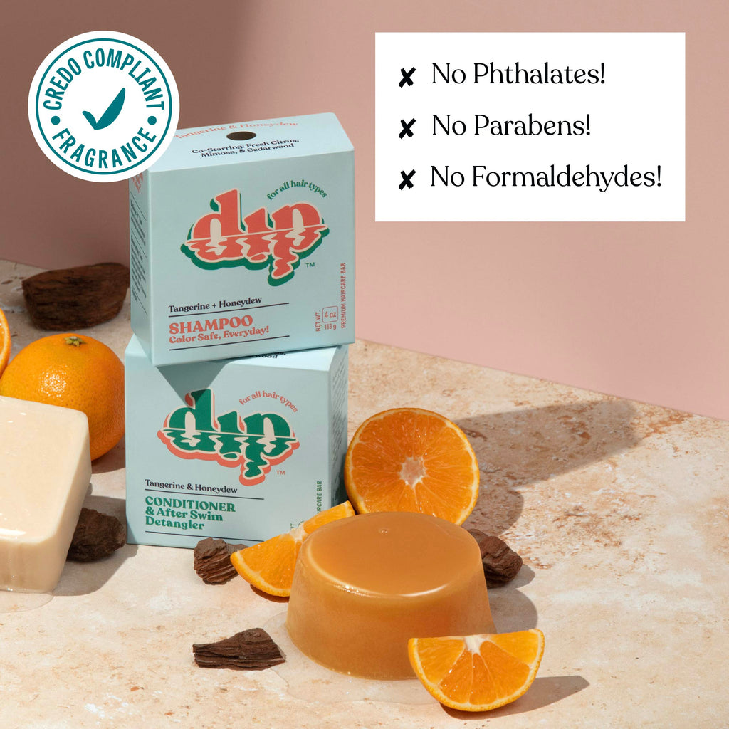Dip shampoo and conditioner bars with oranges and soap on a stone surface, featuring a Credio Compliant Fragrance badge.