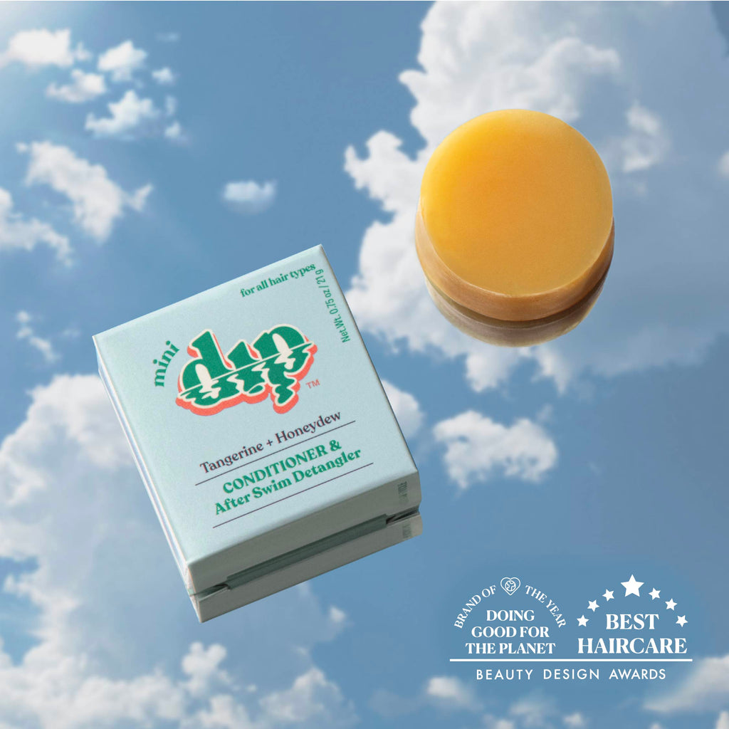 Box of 'mini dip' hair care product with a yellow bar of soap against a cloudy sky background.