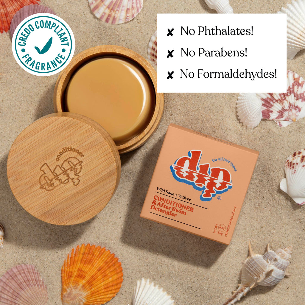 Bottle of conditioner with wooden cap and packaging on a sandy background with seashells.