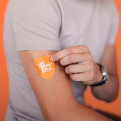 Person wearing an orange patch on their arm with a brand logo against an orange background