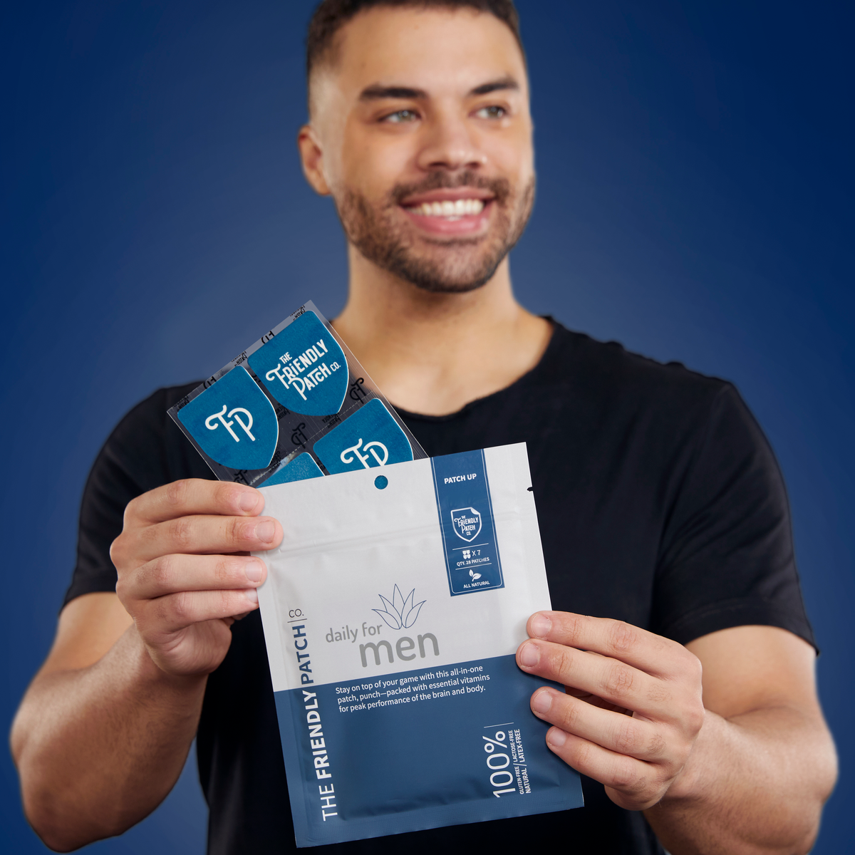 Man holding packages of 'The Friendly Patch' for men against a blue background