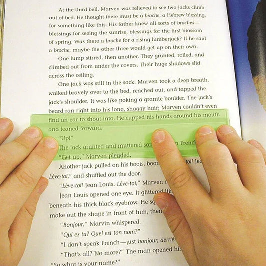 Hands using a green reading guide strip over a book page, aids focus and reading comprehension