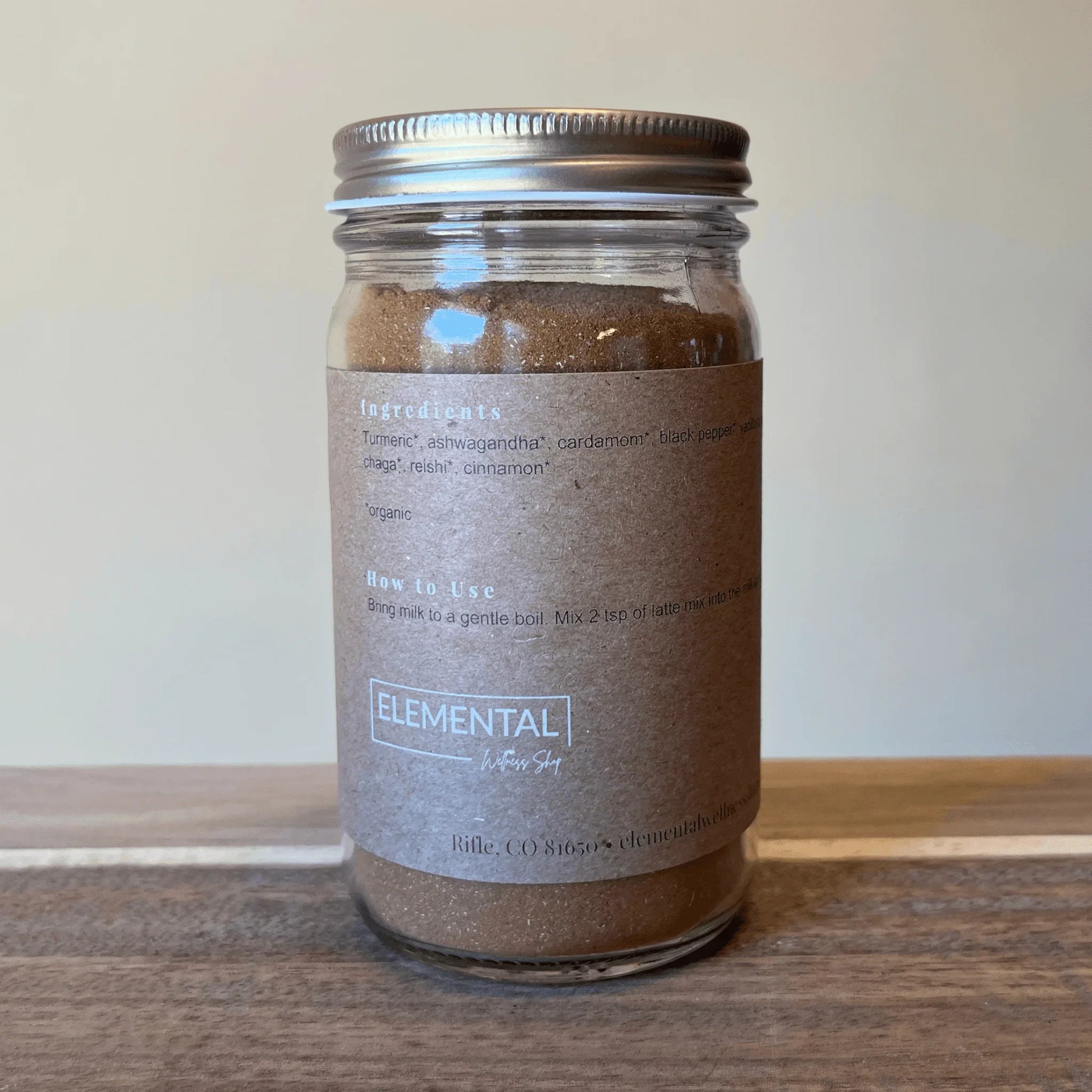 Glass jar with golden milk latte mix, labeled ingredients like turmeric and ashwagandha.