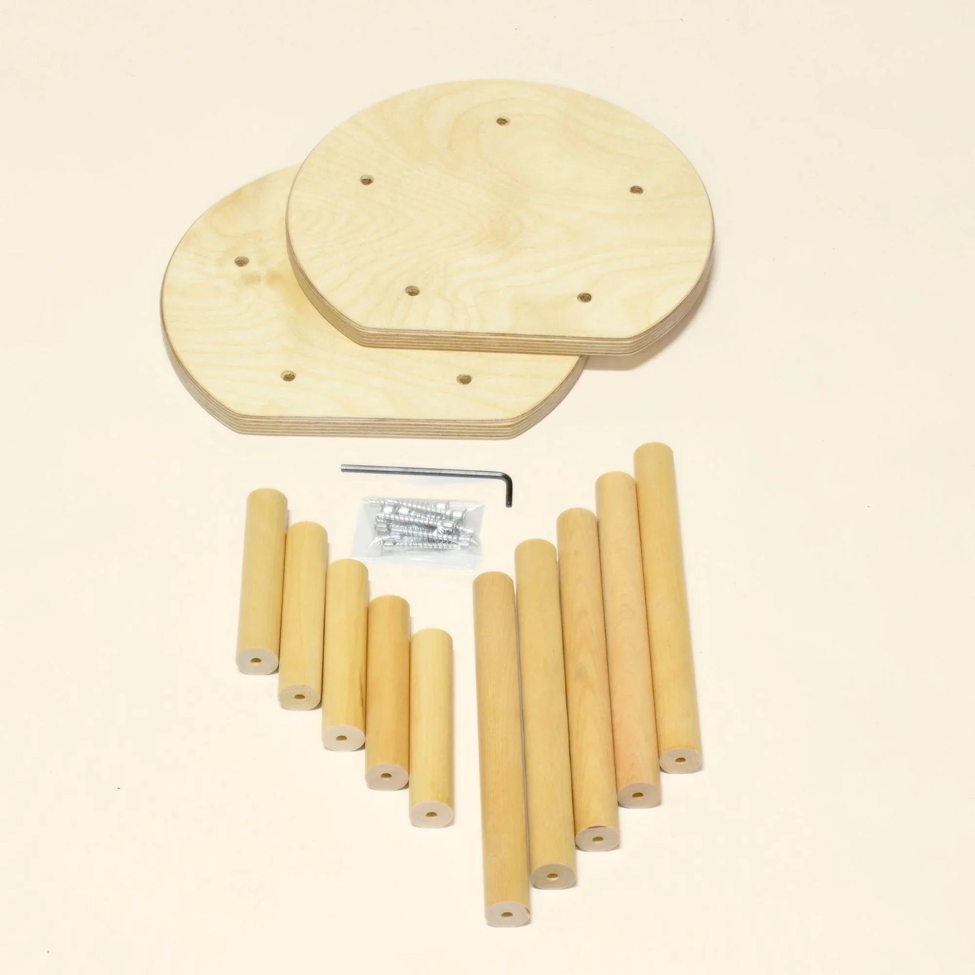 Wooden stool parts kit with round seats, dowel legs, screws, and hex key on a beige background.