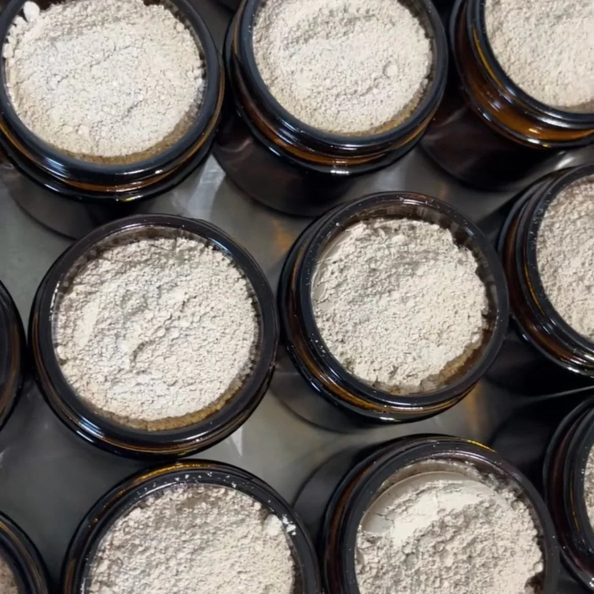Close-up of glass jars filled with natural herbal tooth powder for oral care