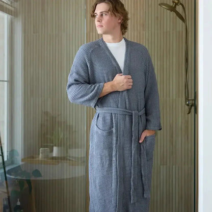 Man wearing a gray sensory-friendly waffle robe in a modern bathroom setting